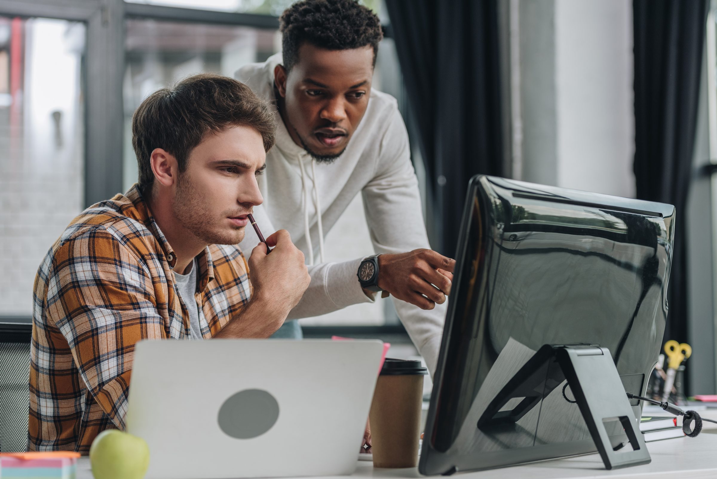 Two engineers reviewing work on a monitor together