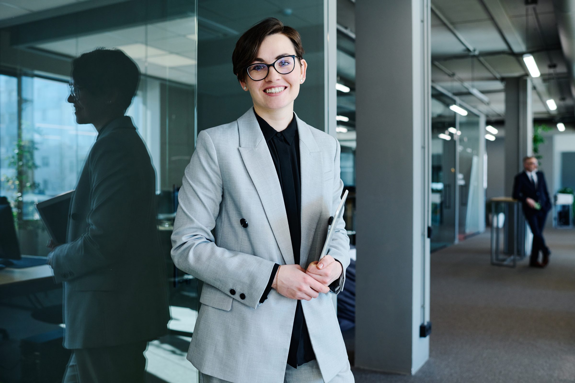 A woman in a light blazer in an office corridor